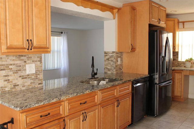 kitchen with stainless steel fridge with ice dispenser, dishwasher, light stone countertops, and sink