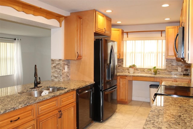 kitchen with black appliances, sink, tasteful backsplash, light tile patterned flooring, and light stone counters