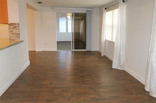 spare room with ceiling fan, plenty of natural light, and dark hardwood / wood-style floors