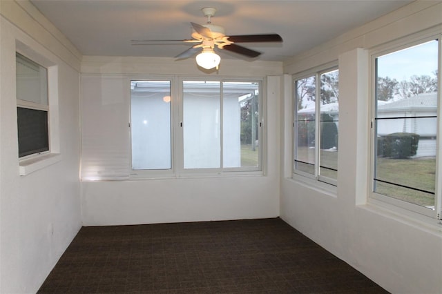 unfurnished sunroom featuring ceiling fan