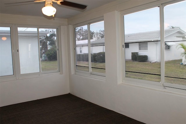 unfurnished sunroom featuring ceiling fan