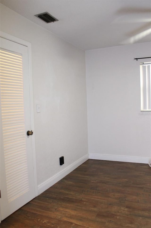 unfurnished room with dark wood-type flooring