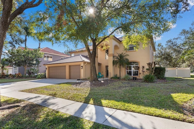 mediterranean / spanish home with a front lawn and a garage