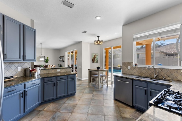 kitchen featuring dishwasher, sink, decorative light fixtures, blue cabinets, and backsplash