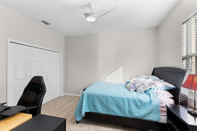 carpeted bedroom with ceiling fan and a closet