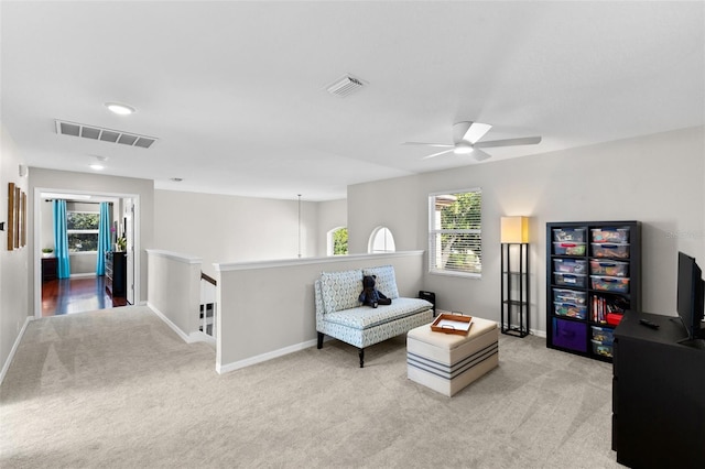 sitting room featuring light colored carpet and ceiling fan