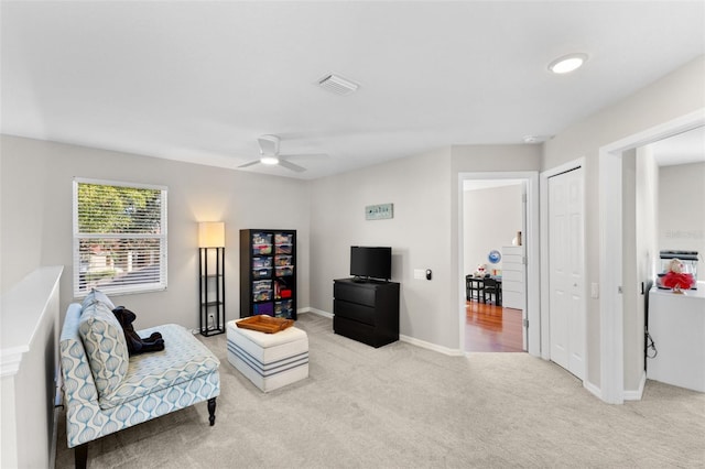 sitting room featuring ceiling fan and light colored carpet