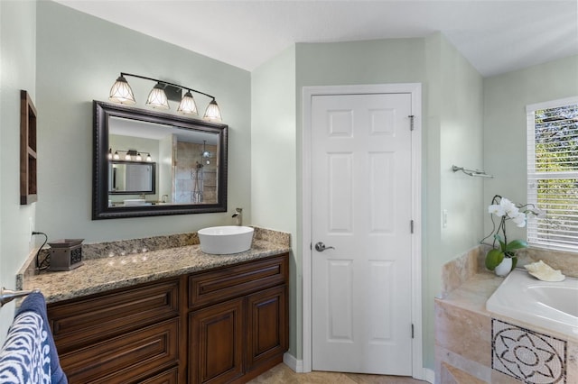 bathroom with tiled tub and vanity