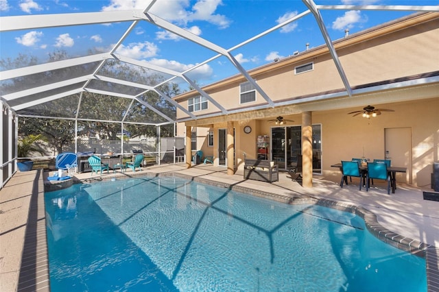 view of swimming pool featuring a patio area, ceiling fan, and glass enclosure