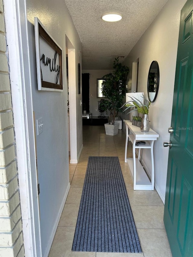 corridor with light tile patterned floors and a textured ceiling