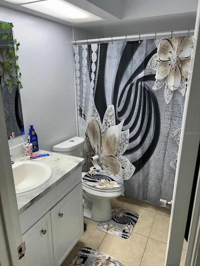 bathroom featuring tile patterned flooring, vanity, and toilet