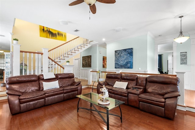 living room featuring stairway, wood-type flooring, and crown molding