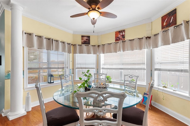 sunroom featuring a healthy amount of sunlight, a ceiling fan, and decorative columns