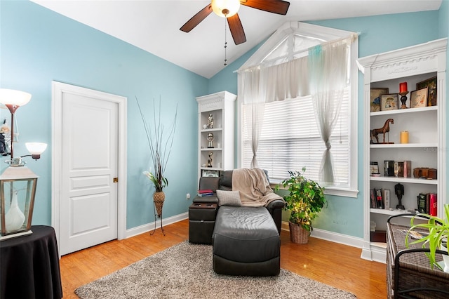 sitting room featuring baseboards, light wood-type flooring, ceiling fan, and vaulted ceiling