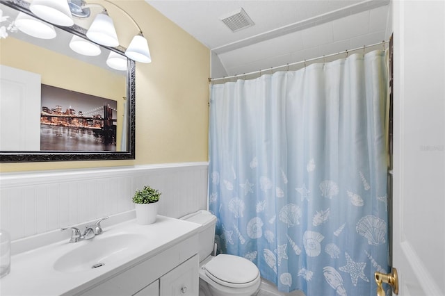 bathroom featuring visible vents, toilet, a shower with curtain, wainscoting, and vanity