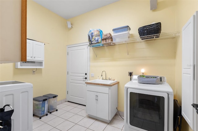 laundry room featuring light tile patterned floors, cabinet space, electric dryer hookup, and a sink