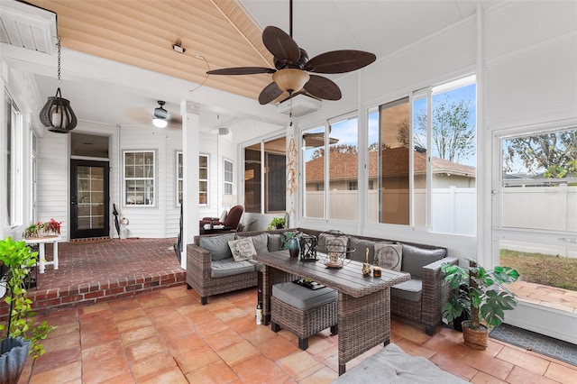 sunroom / solarium featuring a ceiling fan