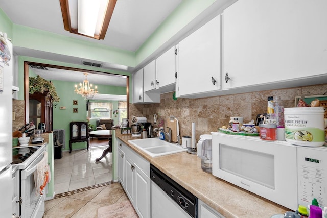 kitchen featuring decorative light fixtures, sink, white cabinets, light tile patterned floors, and white appliances