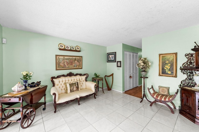 sitting room with a textured ceiling and light tile patterned floors