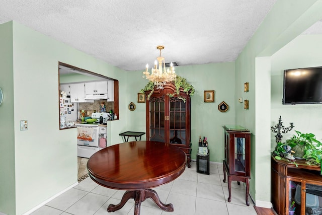 dining space with a notable chandelier, a textured ceiling, and light tile patterned floors