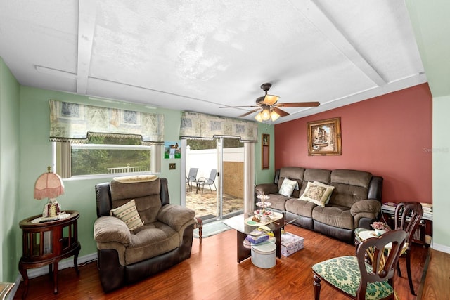 living room featuring a textured ceiling, wood-type flooring, and ceiling fan