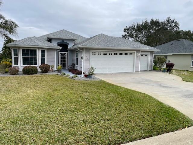 single story home with a front yard and a garage