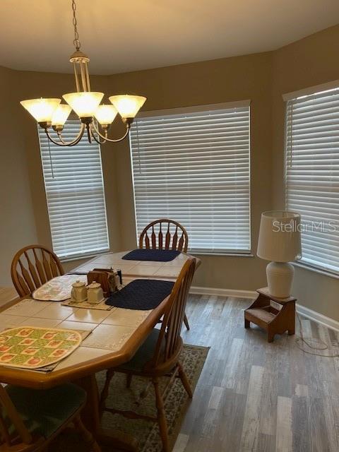 dining area with hardwood / wood-style flooring and a notable chandelier