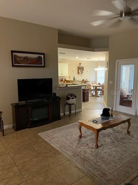 tiled living room featuring ceiling fan