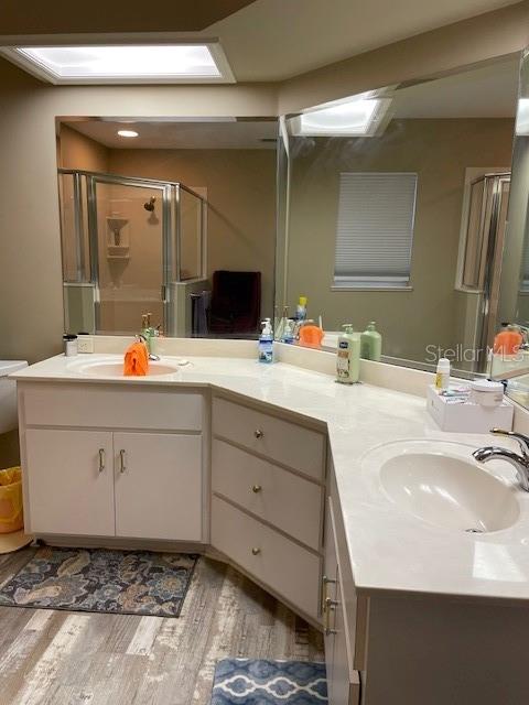 bathroom with vanity, an enclosed shower, and hardwood / wood-style flooring