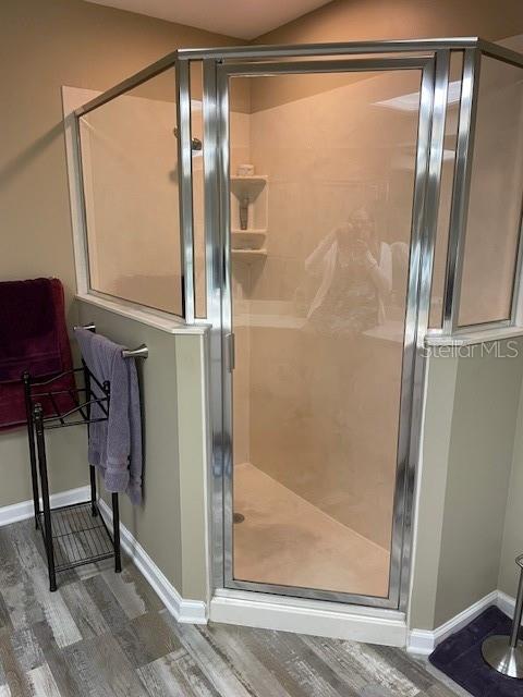 bathroom featuring hardwood / wood-style floors and a shower with door