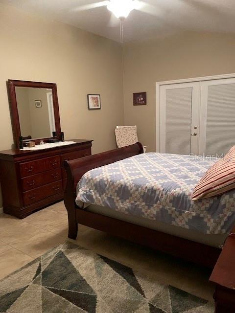 tiled bedroom featuring ceiling fan