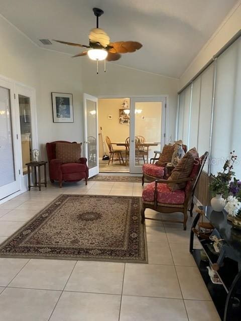 living room with lofted ceiling, ceiling fan, and light tile patterned floors