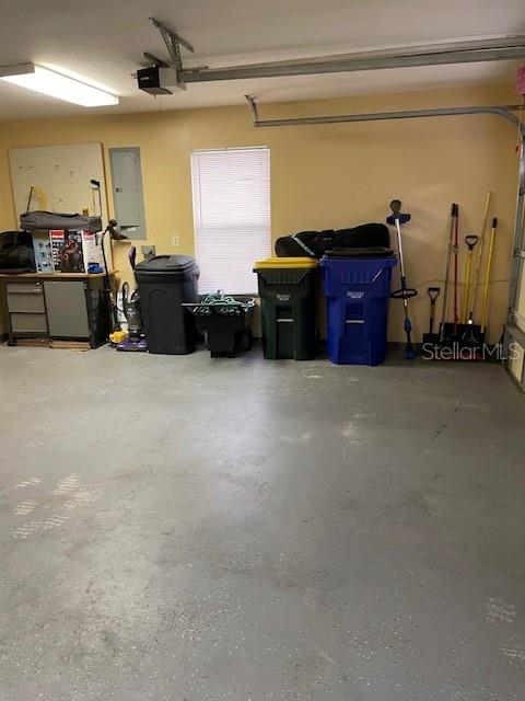 garage featuring electric panel and a garage door opener