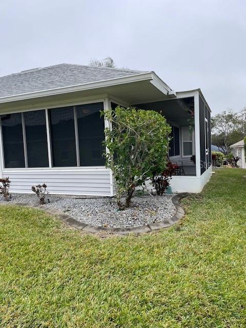 view of side of property with a lawn and a sunroom