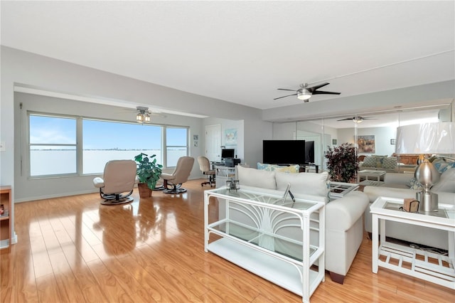 living room featuring light hardwood / wood-style flooring and ceiling fan