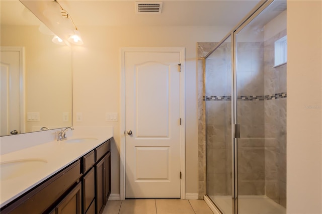 bathroom with tile patterned floors, a shower with door, and vanity