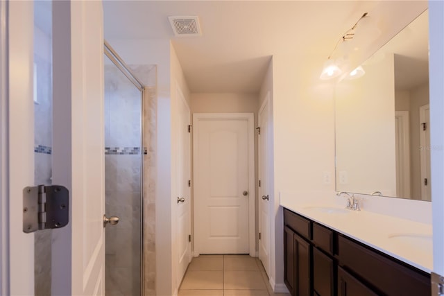 bathroom with walk in shower, vanity, and tile patterned flooring