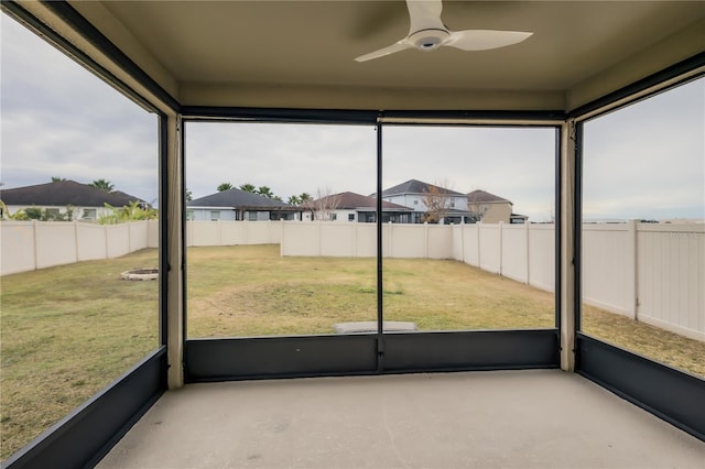 unfurnished sunroom featuring ceiling fan