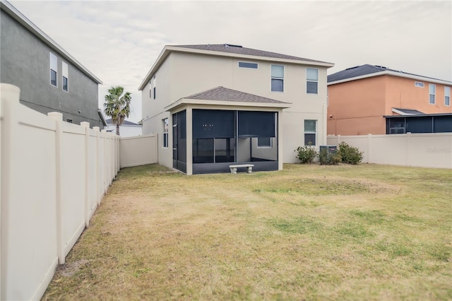 back of property featuring a yard and a sunroom