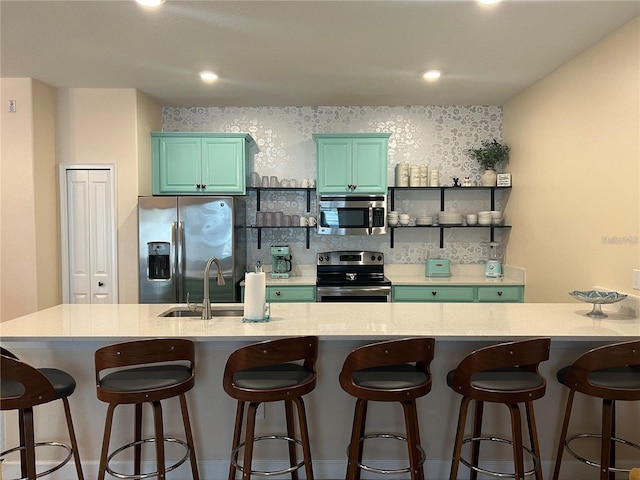 kitchen with a breakfast bar area, sink, and appliances with stainless steel finishes