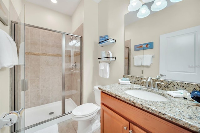 bathroom with toilet, vanity, tile patterned floors, and walk in shower