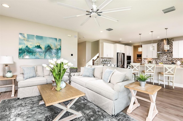 living room featuring hardwood / wood-style flooring and ceiling fan