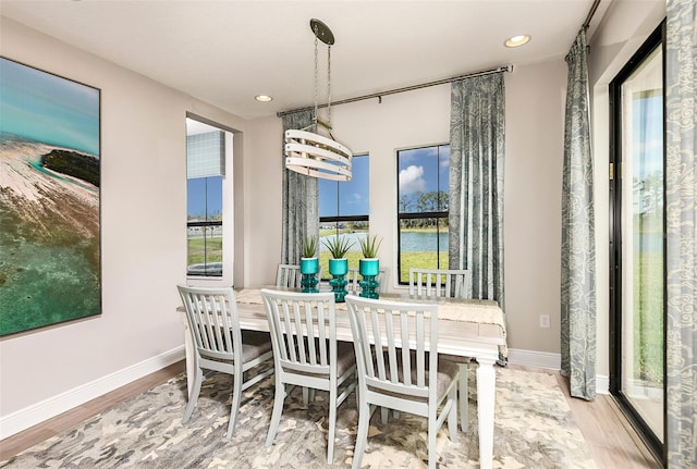 dining space with light hardwood / wood-style flooring and an inviting chandelier