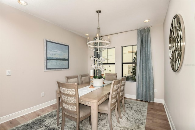 dining room featuring wood-type flooring and an inviting chandelier