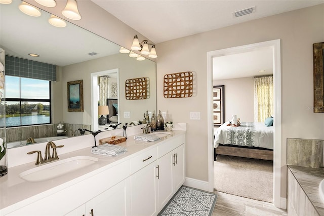 bathroom featuring vanity, a washtub, and a water view