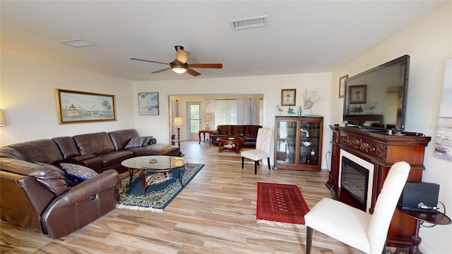 living room with ceiling fan and light hardwood / wood-style flooring