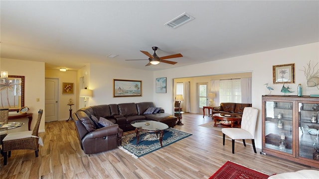 living room with light hardwood / wood-style flooring and ceiling fan