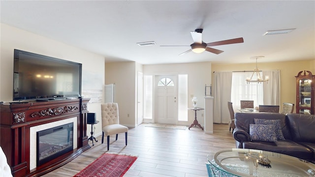 living room featuring light wood-type flooring and a notable chandelier