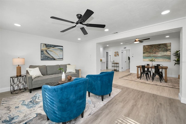 living room featuring ceiling fan and light hardwood / wood-style floors