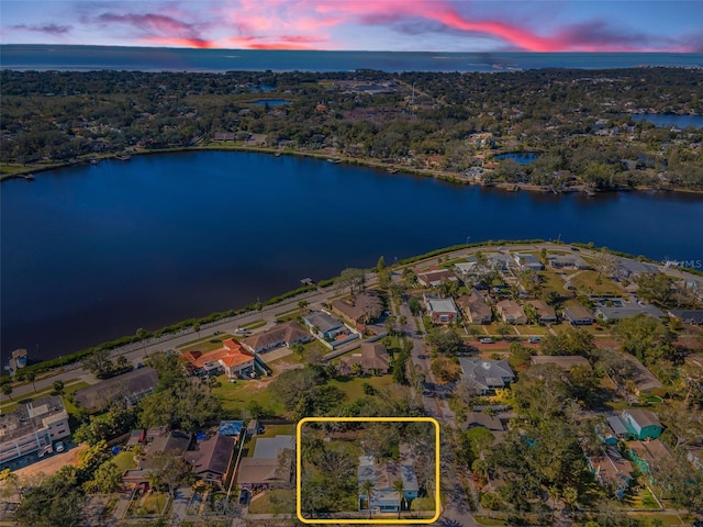 aerial view at dusk featuring a water view